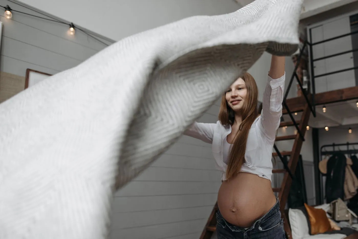 Těhotná žena natahuje svetr přes rostoucí bříško