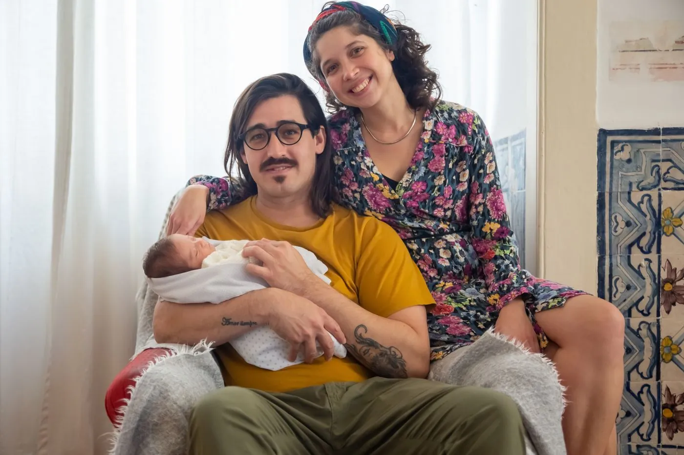 Rodiče objímají partnera s miminkem v náručí